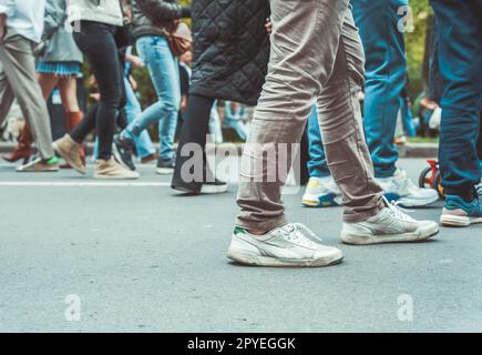 Nahaufnahme mit vielen Füßen, die auf der Straße laufen Stockfoto