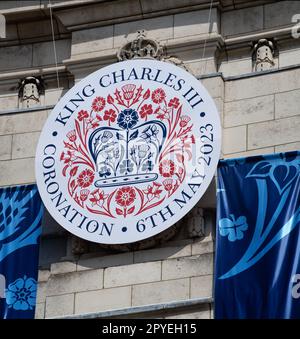 Das offizielle Logo der Krönung von König Karl dem Dritten als Teil der „Happy & Glorious“-Banner, die von Admiralty Arch, London, hängen Stockfoto