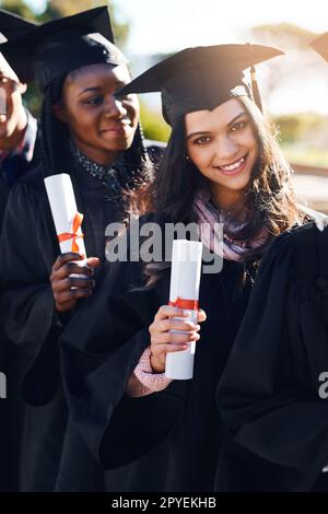 Bildung ist der Schlüssel zur Erschließung der Welt. Porträt einer Schülergruppe, die am Abschlusstag in einer Schlange steht. Stockfoto