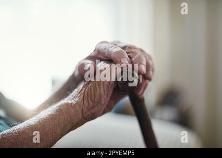 Keine Balanceängste mehr für mich. Ein nicht wiedererkennbarer Mann, der sich auf seinen Gehstock lehnt. Stockfoto