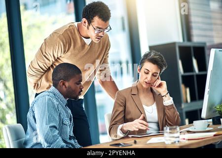 Mit kreativen Ideen zusammenkommen. Drei Designer führen ein Brainstorming im Büro durch. Stockfoto