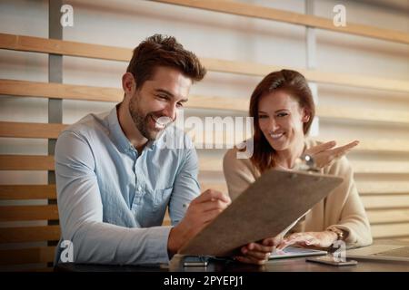 Das Geschäft sieht gut aus. Zwei Geschäftsleute treffen sich in einem Café. Stockfoto