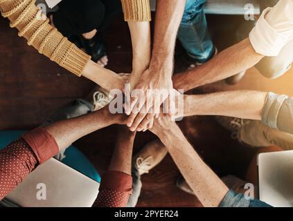 Es ist einfacher, wenn wir unsere Anstrengungen als Gruppe bündeln. Aus dem Blickwinkel, wie eine Gruppe unbekannter Geschäftsleute ihre Hände in einem Zusammentreffen zusammenfasst. Stockfoto