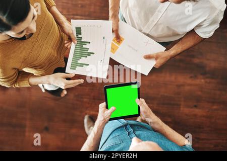 Die neuesten Geschäftsberichte durchgehen. Aufnahmen aus dem Blickwinkel einer Gruppe von unbekannten Geschäftsleuten, die in einem Büro Brainstorming durchführen. Stockfoto