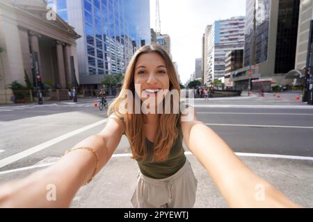 Ein wunderschönes lächelndes Mädchen macht Selbstporträts auf der Paulista Avenue, Sao Paulo, Brasilien Stockfoto