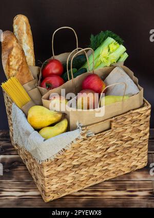 Frisches Gemüse, Gemüse und Obst, Müsli und Pasta in einem Korb aus Korb aus Korb aus Korb. Konzept der Lieferung oder Spende von Lebensmitteln. Stockfoto