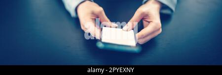 Eine Frau, die ein modernes Mobiltelefon in der Hand hält. Stockfoto