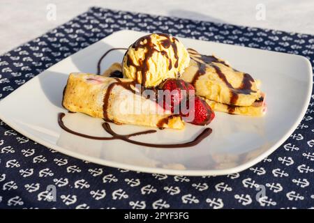 Palacsinta, traditionelle ungarische süße Pfannkuchen serviert mit Obst und einer Kugel Eis, köstliches Dessert Stockfoto