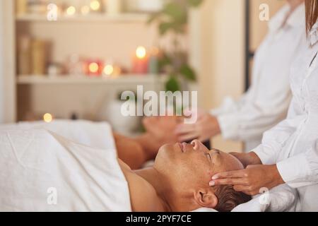 Massage, reiki und Paar im Spa mit Therapeutin Hand, Chakra Balance mit Wellness, spirituelle und Selbstpflege. Ruhe, Zen und Luxus Service mit Masseuse, Relax und psychische Gesundheit Urlaub in Bali Stockfoto