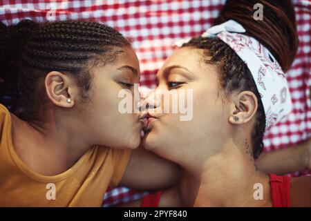 Liebe macht das Leben heller. Der große Winkel, wie ein kleines Mädchen ihrer Mutter einen Kuss gibt. Stockfoto