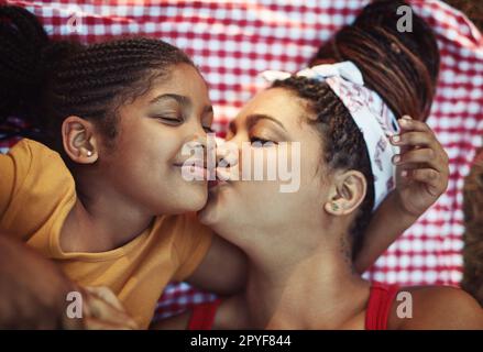 Küsse für meine süßeste. Ein Foto von einer Mutter, die ihrer kleinen Tochter einen Kuss auf die Wange gibt. Stockfoto