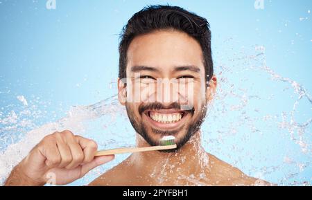 Wasserspritzer, Porträt oder Zahnbürsten im Studio mit Zahnbürste für weiße Zähne oder Mundpflege. Gesicht, Zahnpasta oder glückliche Person, die den Mund mit einem gesunden Zahnlächeln reinigt oder wäscht Stockfoto
