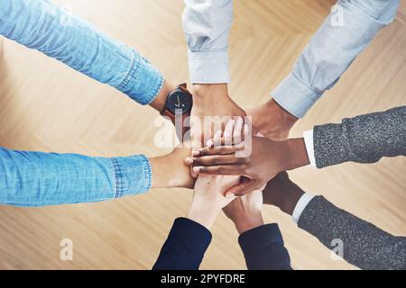 Geben wir unser Bestes. Aus dem Blickwinkel, wie eine Gruppe unidentifizierbarer Geschäftsleute ihre Hände in Einheit vereint. Stockfoto