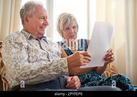 In den letzten Jahren immer finanziell klug bleiben. Ein älteres Paar, das zu Hause seine Papiere zusammen durchsucht. Stockfoto