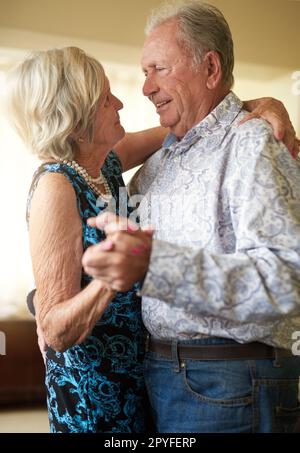 Momente, die mit Liebe gemacht wurden, dauern ewig. Ein glückliches Seniorenpaar, das zu Hause tanzt. Stockfoto