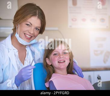 Die Zahnfee hat mich dazu gezwungen. Porträt einer Zahnarztfrau mit ihrer jungen Patientin. Stockfoto