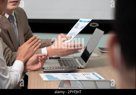 Geschäftsleute treffen sich im Konferenzraum mit einem Laptop und diskutieren mit Geschäftsdokumenten. Stockfoto