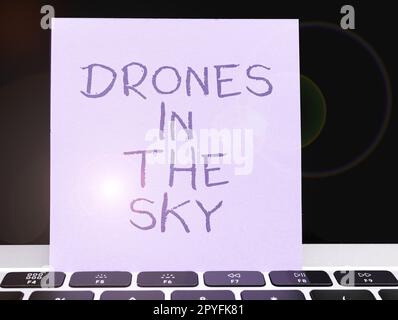Schild mit Drohnen im Himmel. Konzeptionelle fotomoderne Luftkameratechnologie Stockfoto