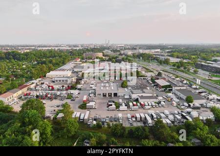 Logistiklager im Vorstadtbereich, Luftaufnahme. Industriezentrum mit Fabrik und abgestelltem Fahrzeug auf Parkplatz. Stockfoto