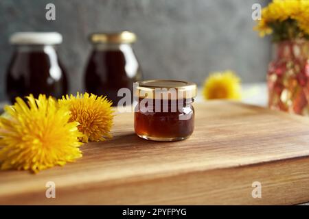 Kleines Glas mit Löwenzahn-Honig - Sirup aus frischen Blumen im Frühling Stockfoto