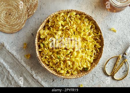 Frische goldene Nesselblumen in einem Korb auf einem Tisch, Draufsicht Stockfoto