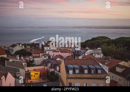 Sonnenuntergang über Gebäuden und dem Fluss Tejo in Lissabon, Portugal. Architektur und Natur in Europa Stockfoto