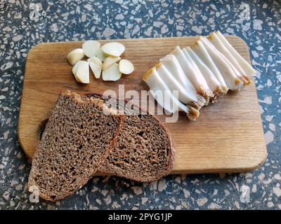 Salo-Brot und Knoblauch auf einem Holzbrett Stockfoto