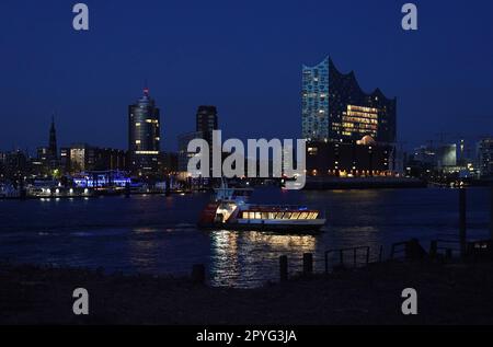 Hamburg, Deutschland. 03. Mai 2023. Eine HVV-Hafenfähre fährt auf der Elbe im Hafen während der blauen Stunde. Kredit: Marcus Brandt/dpa/Alamy Live News Stockfoto