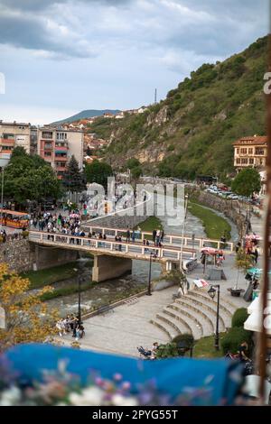 Eine Gruppe verschiedener Menschen, die an einem sonnigen Tag über eine Brücke in der Stadt Prishtina, Kosovo, spazieren Stockfoto