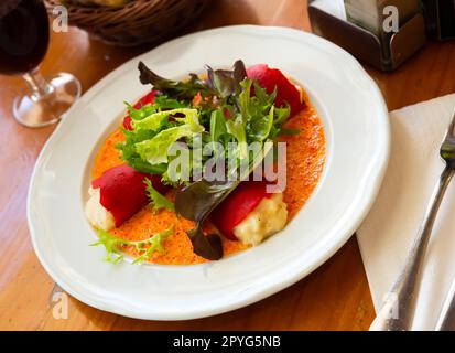 Leckere gefüllte Piquillo-Paprika mit Kabeljau-Brandade in Sauce Stockfoto