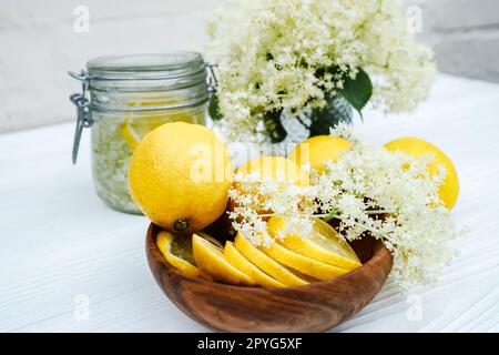 Frische Zitronenscheiben auf einem Holzteller. Zutaten für Kräutertee aus älterem Sirup. Schnelle Ambukusstängel, bereit für einen kalten Sommerdrink Stockfoto