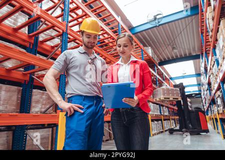 Manager und Arbeiter im Hochregallager sprechen über Geschäfte Stockfoto