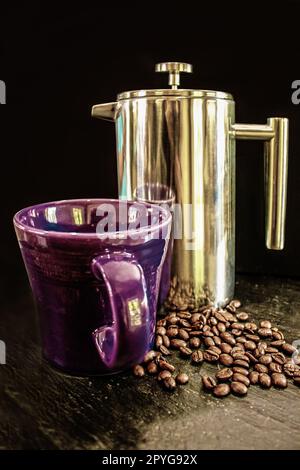 Lila Tasse und verchromte French Press und Kaffeebohnen auf schwarzem Hintergrund auf rauer Schieferoberfläche Stockfoto