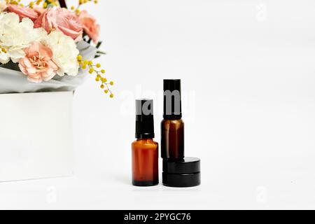 Kosmetik-Schönheitsprodukt-Flaschenmodell und Blume Stockfoto