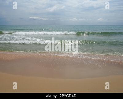 Sommermeer mit glatten Wellen, blauem Himmel, Sand und freiem Platz. Sanfte blaue Meereswelle oder klares Meer am sauberen Sandstrand Sommerkonzept. Traumhafte Strandlandschaft. Schaum auf Meerwasser Stockfoto