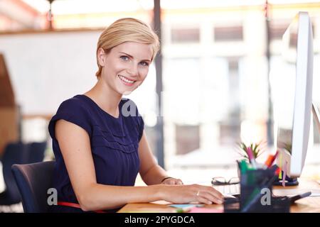 Ich werde den Job erledigen. Abgeschnittenes Porträt eine attraktive junge Geschäftsfrau, die an ihrem Computer arbeitet. Stockfoto