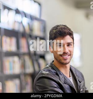 Man hört nie auf zu lernen, weil das Leben nie aufhört zu unterrichten. Porträt eines gutaussehenden Studenten in einer Universitätsbibliothek. Stockfoto