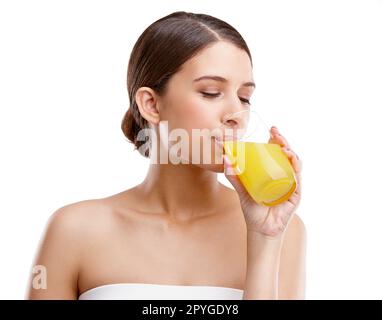 Ich hole Zitrusfrüchte. Studiofoto einer attraktiven jungen Frau, die ein Glas Orangensaft trinkt. Stockfoto