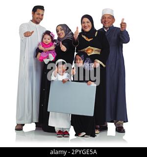 Sie sind eine begeisterte Familie. Studio-Porträt einer glücklichen muslimischen Familie mit einem leeren Schild isoliert auf weiß. Stockfoto