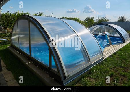 Swimmingpool (im Freien) mit Schiebeabdeckung. Wetterschutz Stockfoto