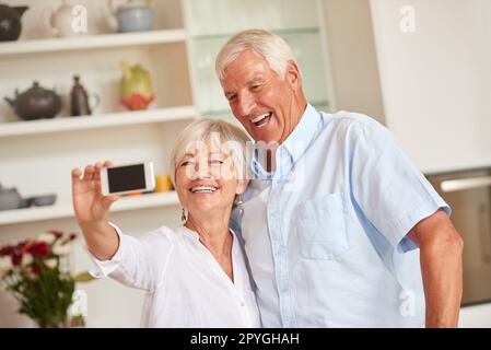 Lächeln, Schatz. Ein Seniorenpaar, das ein Selfie mit seinem Handy macht. Stockfoto
