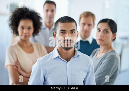 Gemeinsam schaffen wir es. Porträt einer Gruppe unterschiedlicher Kollegen, die in einem Büro stehen. Stockfoto