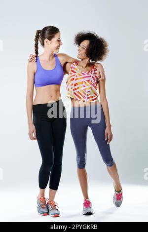 Sie ist ein positiver Trainingspartner. Zwei Frauen, die in Sportkleidung in einem Studio stehen. Stockfoto