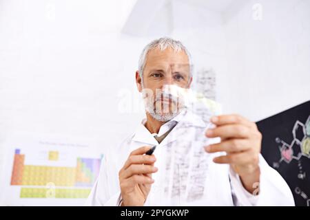 Enthüllen von DNA-Rätseln. Ein männlicher Wissenschaftler, der die Ergebnisse eines DNA-Tests analysiert. Stockfoto