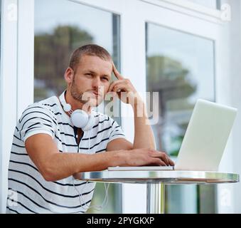 Mit der nächsten großen Sache. Ein gutaussehender junger Mann, der draußen an einem Laptop arbeitet. Stockfoto