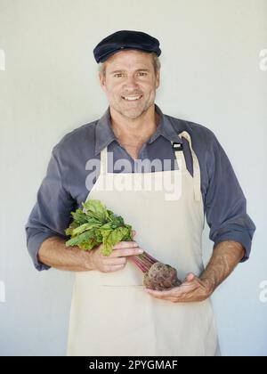 Alle Vitamine in einem Gemüse. Ein reifer Mann, der einen Haufen Rote Bete in der Hand hat. Stockfoto