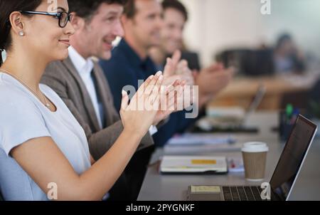 Großartige Präsentation. Geschäftsleute klatschen, während sie an einem Tisch in einem Büro sitzen. Stockfoto