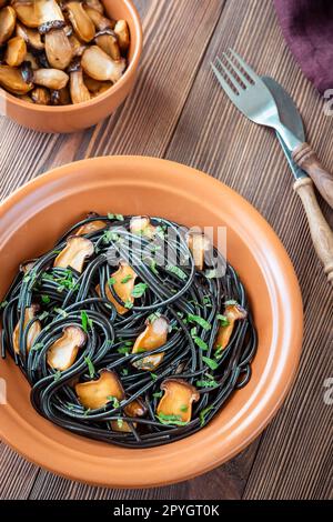 Schwarze Pasta mit Pilzen Stockfoto