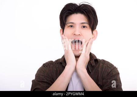 Ein überraschter junger Mann, der in die Kamera schaut Stockfoto