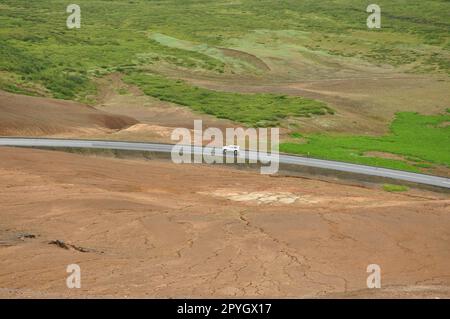 Luftaufnahme eines Autos auf einer einsamen Straße in einem Tal in der Nähe des Hochtemperaturgebiets in Hverir, Island Stockfoto